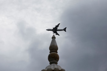Un avión pasa junto a un monumento con nubes de lluvia de fondo en Karachi, Pakistán (REUTERS/Akhtar Soomro/Archivo)