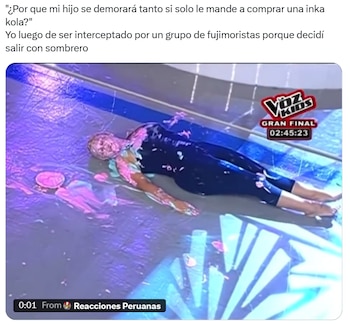 Una persona, cubierta de sustancia rosa y azul, yace boca abajo sobre un suelo mojado y brillante en un escenario, con salpicaduras a su alrededor
