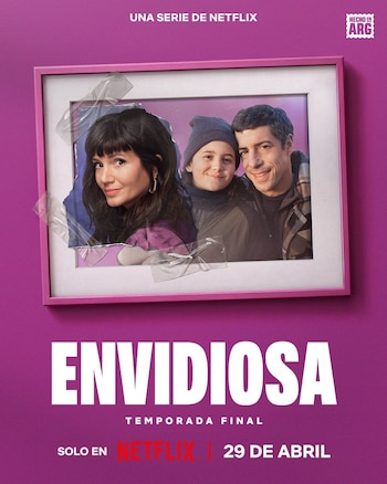 Póster magenta de Envidiosa con un retrato familiar enmarcado, mostrando a una mujer, una niña y un hombre sonriendo, pegado con cinta