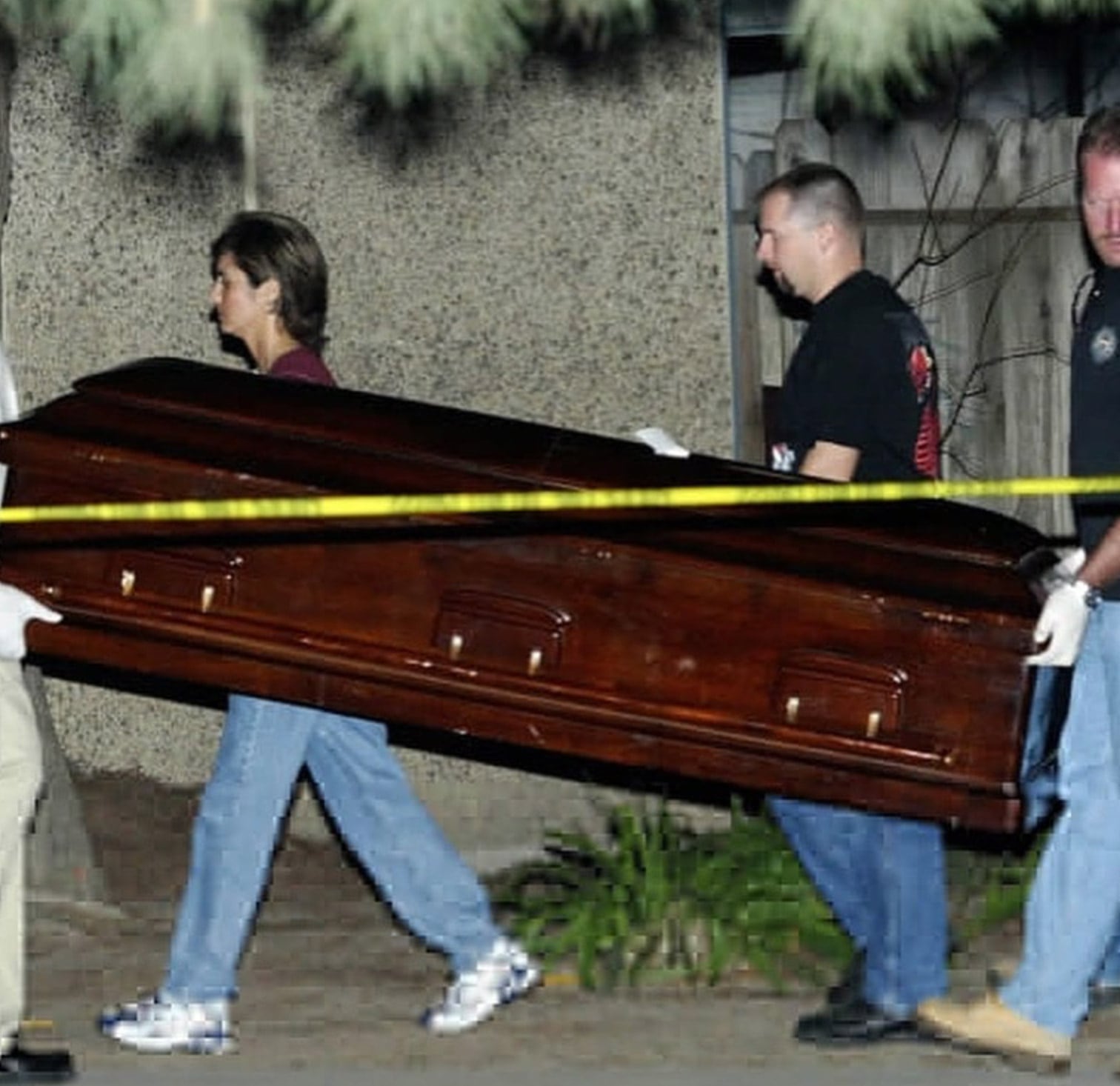Agentes de policía y trabajadores de Fresno sacan un ataúd de la vivienda de Marcus Wesson en Fresno, California, el lunes 15 de marzo de 2004. Wesson había sido detenido el viernes anterior en su domicilio, donde las autoridades hallaron nueve cadáveres (AP Photo/Jeff Chiu)
