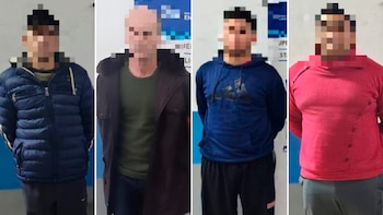 Cuatro hombres con los rostros pixelados posan de pie frente a paredes con el torso hacia el frente y las manos a la espalda