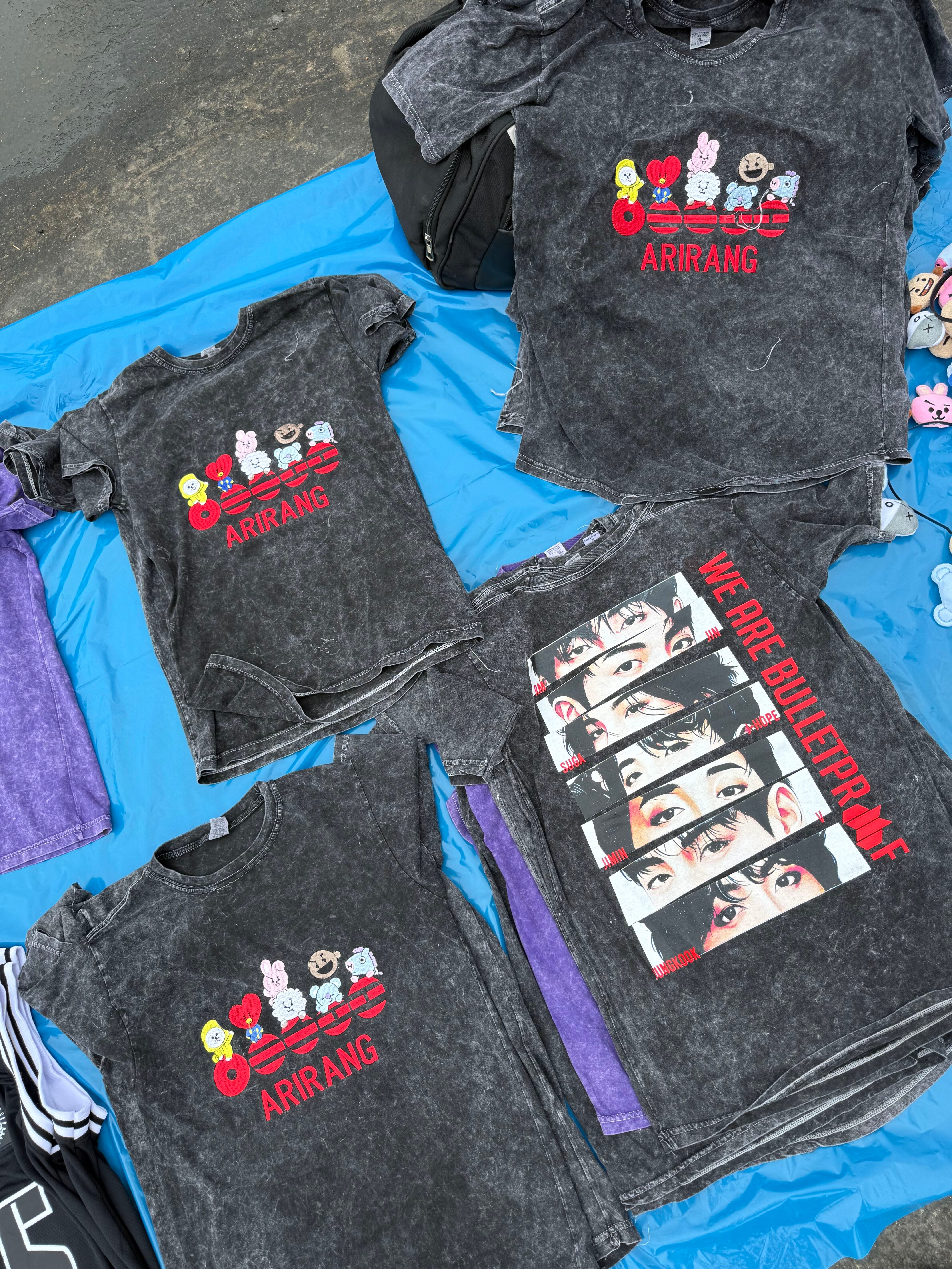 Comerciantes ambulantes ofrecen camisetas con diseños del grupo surcoreano BTS en las afueras del Estadio San Marcos en Lima. (Paula Díaz)