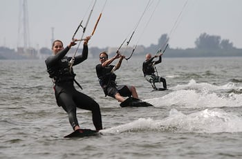 Tres generaciones de la familia Brackins (abuelo, hijo y nieta) haciendo kitesurf juntos