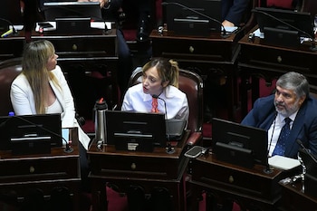 Anabel Fernández Sagasti hablando en un micrófono en una sesión parlamentaria, con una mujer rubia y un hombre barbudo sentados a su lado en escritorios