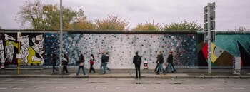 La gente se reúne en una pintura en la llamada East Side Gallery, un lugar popular para el arte de la calle en los restos del Muro de Berlín