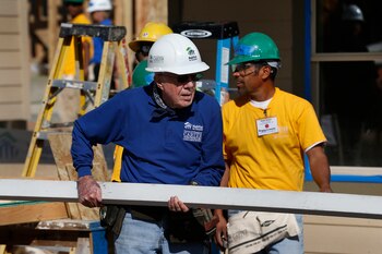 El expresidente Jimmy Carter, entonces de 89 años, ayuda a cortar madera para la construcción de una casa en un sitio de construcción de Habitat for Humanity en el vecindario Globeville de Denver, el 9 de octubre de 2013. (Foto AP/Brennan Linsley, Archivo)