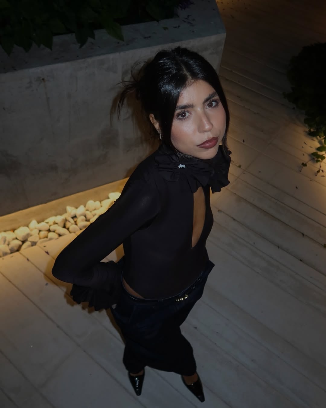 Cami Mayan posa durante la íntima celebración de su cumpleaños número 27, rodeada de amigos y luciendo un elegante atuendo oscuro.