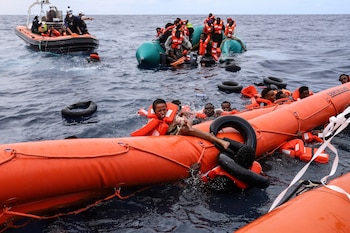 Migrantes que cayeron al agua intentan aferrarse a un flotador antes de ser rescatados por activistas, a unos 56 kilómetros (34 millas) de Libia, el 18 de octubre de 2021, en el mar Mediterráneo. (AP Foto/Valeria Mongelli, archivo)