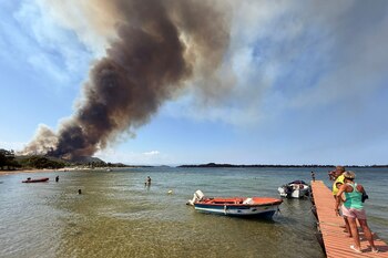 Los bañistas observan el humo