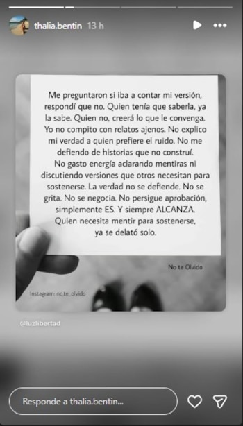 Una mano sostiene una tarjeta rectangular de color blanco y negro con texto. El fondo está desenfocado y muestra la parte inferior de dos figuras