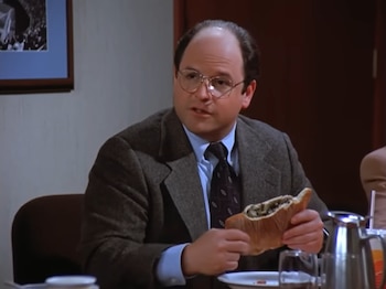 La figura recrea a George Costanza con campera universitaria de los Yankees y remite al episodio The Calzone de la séptima temporada de Seinfeld (Captura de video)