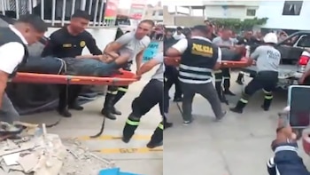Policías y rescatistas trasladan en camilla a un hombre herido hacia una camioneta en una estación de combustible