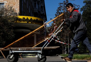 Un trabajador empuja un carro