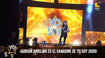 Un hombre vestido de negro canta con micrófono en un escenario con luces y una pantalla que muestra el logotipo del programa Yo Soy