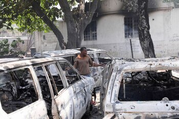 Un hombre reacciona junto a los restos carbonizados de vehículos cerca del palacio presidencial, después de que fueran incendiados por pandillas, en Puerto Príncipe, Haití, el 25 de marzo de 2024 (REUTERS/Ralph Tedy Erol)