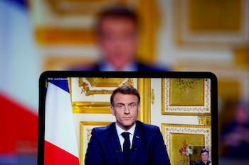 French President Emmanuel Macron appears on screen as he makes a television address to the nation after Prime Minister Michel Barnier's government was toppled in a no confidence vote in parliament, in Paris, France, December 5, 2024. REUTERS/Christian Hartmann