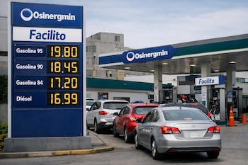 Cartel digital de estación de servicio muestra precios de gasolina y diésel, con logos de Osinergmin y Facilito. Varios autos en fila para cargar combustible.