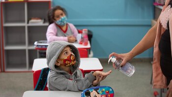 Una docente ofreciéndole alcohol en