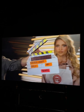 Una claqueta de cine con la palabra MasterChef tapa parcialmente a una mujer rubia vestida con un delantal blanco