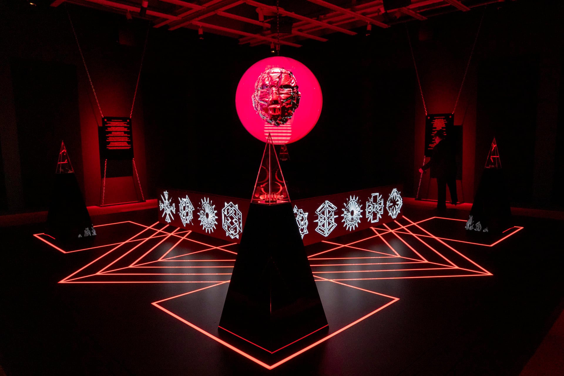 Un visitante mira hacia arriba una gran proyección circular de arte digital inmersivo, en una sala oscura durante la Bienal 2026 del Museo Whitney de Nueva York.