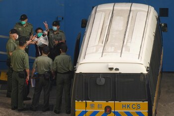 El activista prodemocracia Figo Chan gesticula mientras camina hacia una camioneta de la prisión para dirigirse a la corte por cargos relacionados con una reunión no autorizada. REUTERS/Lam Yik