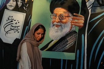 Una mujer al lado de un mural con el retrato del ex líder supremo iraní Ali Khamenei, en Teherán, el 18 de julio del 2026 (AP foto/Vahid Salemi)