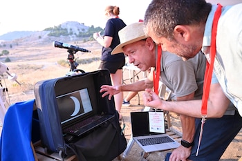 Investigadores del Instituto de Astrofísica de Canarias (IAC) registran con sus telescopios, desde los pies del Cristo del Otero. (EFE/Almudena Álvarez)