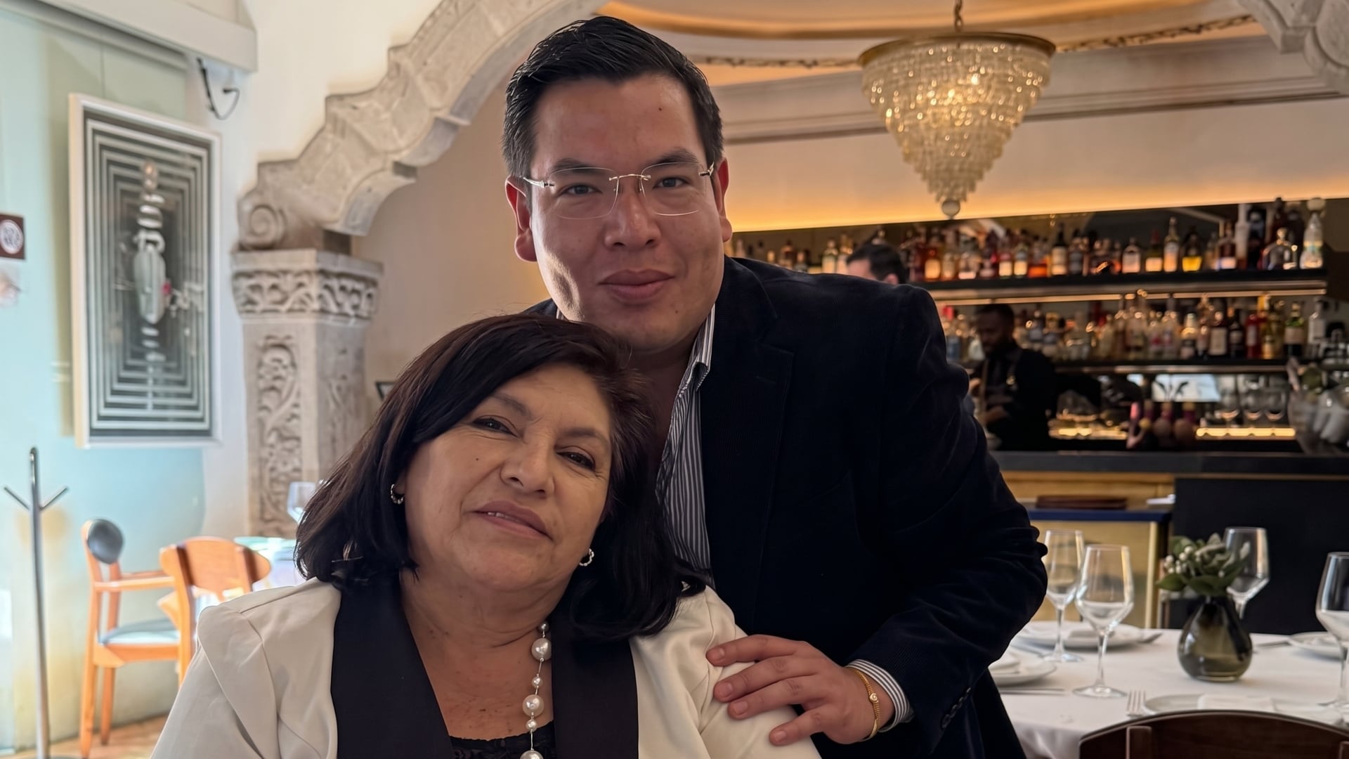 Jaime Lara posa con su madre, la regidora Diana Enriqueta Ávila Pérez, en un evento en un restaurante con ambiente elegante. (@JJJMaciasmachica, X)