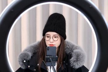 La influencer china y diseñadora de moda, Zhang Dayi, revisa conmentarios de sus seguidores en un teléfono. Su tipo de trabajo se vera afectado por las nuevas regulaciones (Foto: REUTERS)