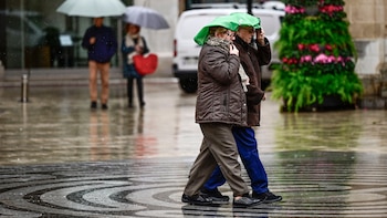 Dos personas se protegen de