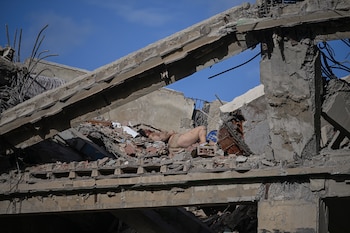 EDITORS NOTE: Graphic content / The body of a victim is seen in the rubble of a damaged apartment building following an earthquake in Catia La Mar, La Guaira state, some 30km north-west of Caracas, on June 25, 2026. A twin earthquake that was Venezuela's largest in over a century has killed at least 164 people and destroyed multiple buildings near the capital, where residents searched on June 25 for missing relatives. (Photo by Federico PARRA / AFP)