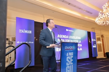 Un hombre con traje habla en un atril frente a pantallas con logotipos de FUNDESA y ENADE en un escenario