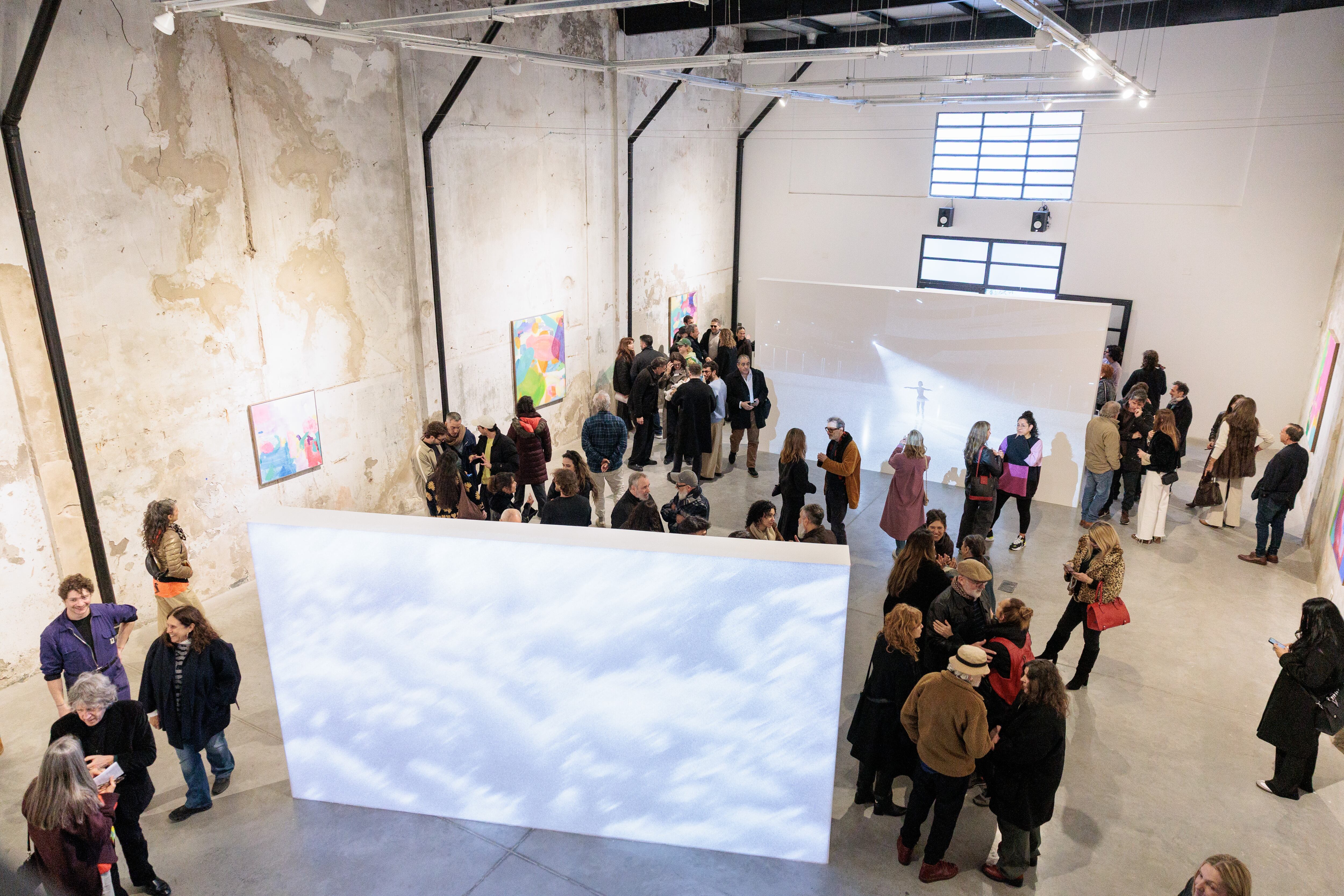 La exposición propone contrastes: el blanco y negro de los videos se contrapone al color de las pinturas; el sonido se diferencia de los textos con poemas que atraviesan el espacio de forma
circular