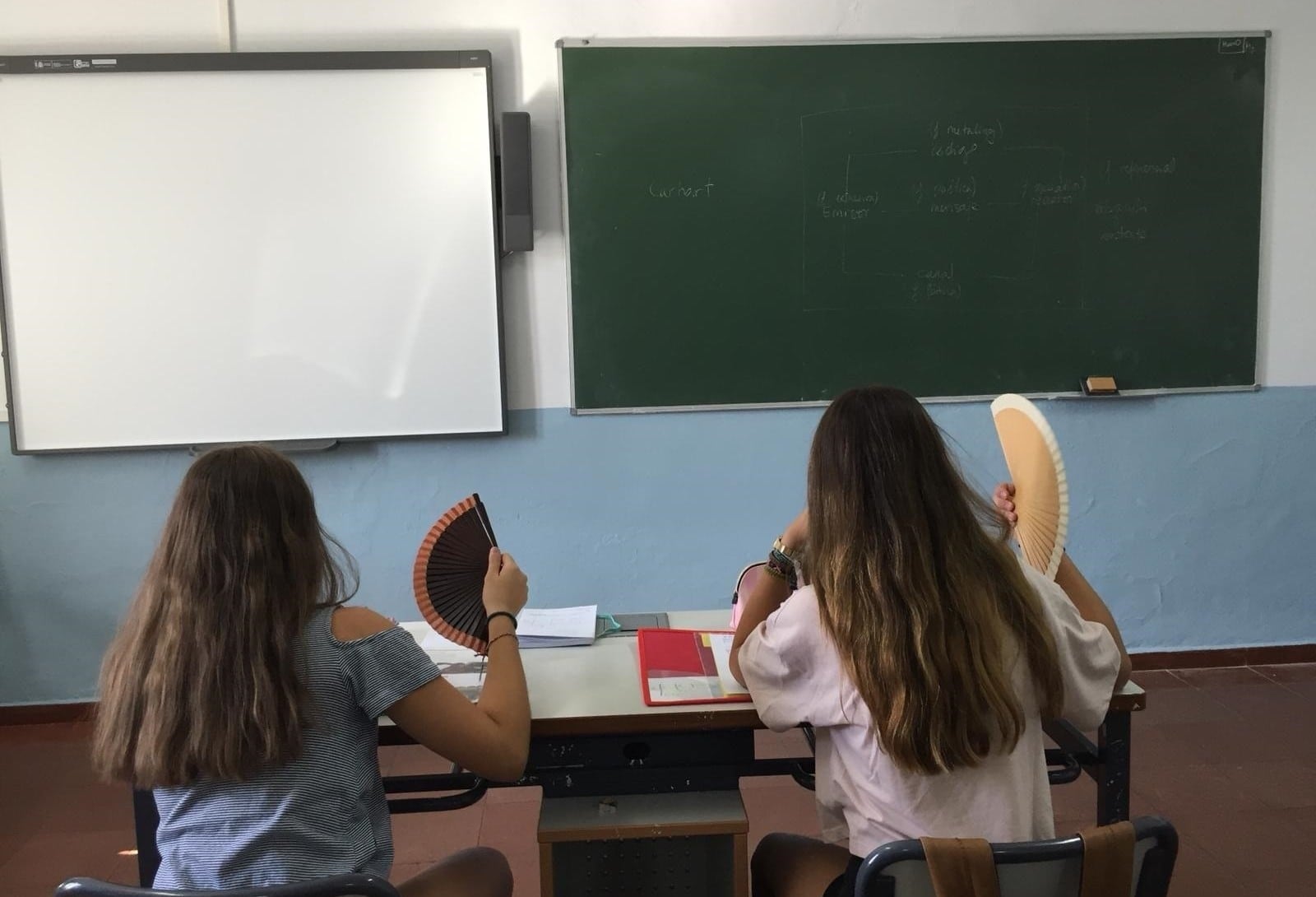 Dos alumnas se abanican en una clase. (Europa Press)