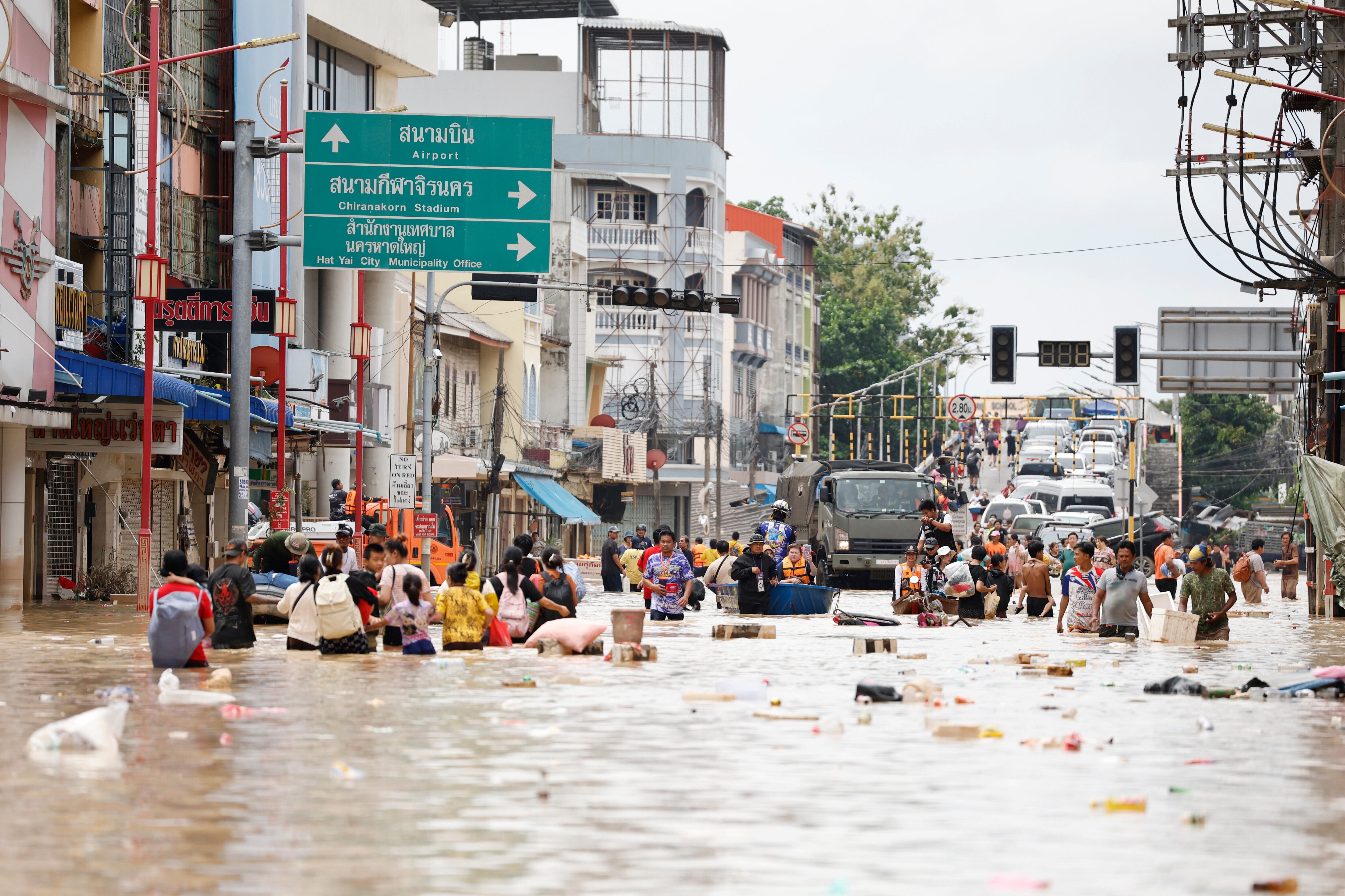 Gente camina entre las aguas inundadas en la provincia de Songkhla (Foto AP/Sarot Meksophawannakul)