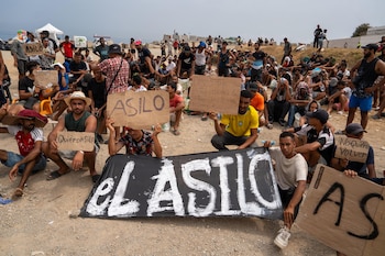 Un grupo de migrantes concentrados para solicitar asilo este domingo en la playa del Trampolín de Ceuta. (EFE / Reduan)