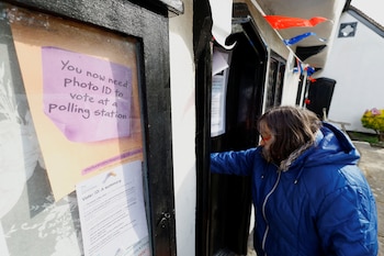 Un cartel recordando a los votantes que presenten identificación con foto (REUTERS/Peter Cziborra)