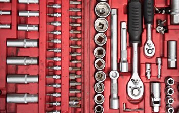 Ein roter Werkzeugkasten mit Schraubenschluesseln