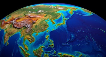 Vista aérea de un mapa digital tridimensional de Asia y el océano Pacífico, con topografía terrestre de verdes a marrones y batimetría oceánica de cian a azul oscuro.