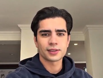 Hombre joven con sudadera azul oscuro sonríe a la cámara. Texto superpuesto: "Agradece los msjs/atenciones que ha recibido." y "LasPeligrosasDeAaron"