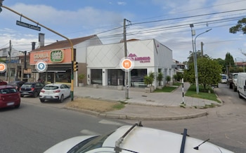 Vista desde una calle hacia dos locales comerciales, uno de color naranja y otro blanco con la inscripción Andino Helados