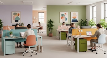 Vista de una oficina con varias mujeres sentadas en escritorios individuales. Hay computadoras, monitores, lámparas, plantas y muebles de colores pastel.