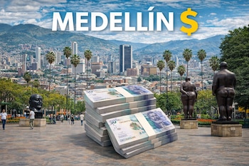 Pilas de billetes de 50.000 pesos colombianos en primer plano con el skyline de Medellín, montañas y varias esculturas de Botero en un día soleado.