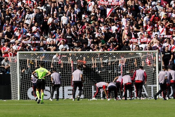 Asistentes recogen los aviones de papel lanzados por la afición rayista en protesta contra la gestión de Martín Presa, antes de que se ordenase la suspensión definitiva del partido de LaLiga entre el Rayo Vallecano y el Athletic de Bilbao, este sábado. (EFE/ Mariscal)