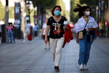 Personas con mascarillas protectoras caminan
