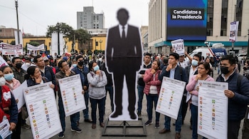 Una multitud de personas observa una gran silueta de candidato presidencial. Muchos sostienen cédulas electorales con listas de opciones, mostrando duda y reflexión.