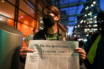 Una mujer sostiene un periódico falso con una lista de supuestos nombres de personas asesinadas en Gaza, durante una concentración en apoyo a los palestinos, mientras continúa el conflicto entre Israel y Hamas, frente al edificio de The New York Times en Nueva York, Estados Unidos, 9 de noviembre de 2023. REUTERS/David Dee Delgado
