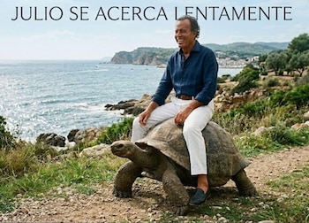 Julio Iglesias sentado sobre una tortuga gigante en un paisaje costero con el mar de fondo y el texto 'JULIO SE ACERCA LENTAMENTE'