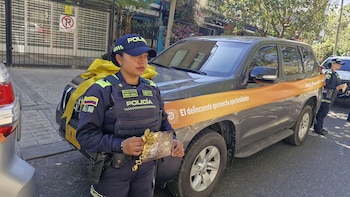 Manillar y espejo retrovisor de un escúter con un lazo dorado atado a la empuñadura