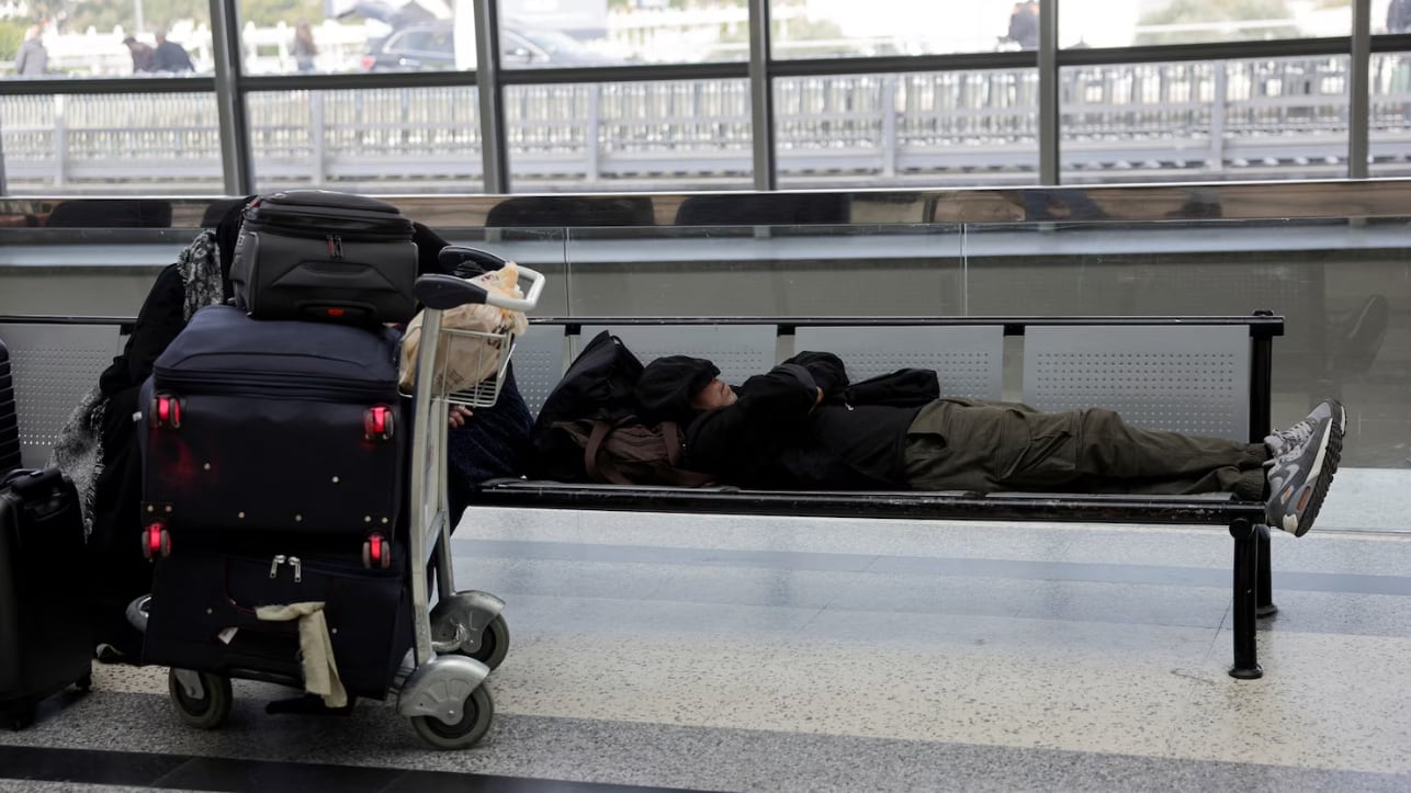 Una persona varada en un aeropuerto (Khalil Ashawi/Reuters)